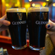 Two pints of Guinness being clinked in a toast